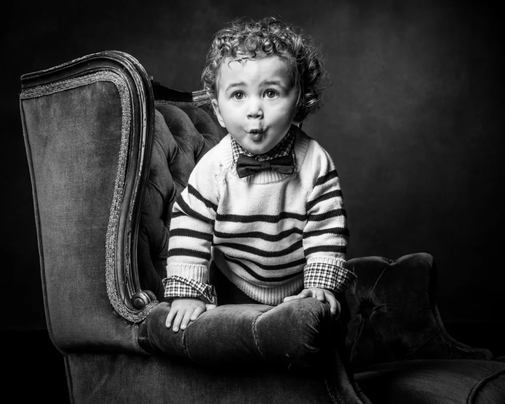 Young boy wearing bow tie during family portrait session at Richard Hill Studio in Dallas