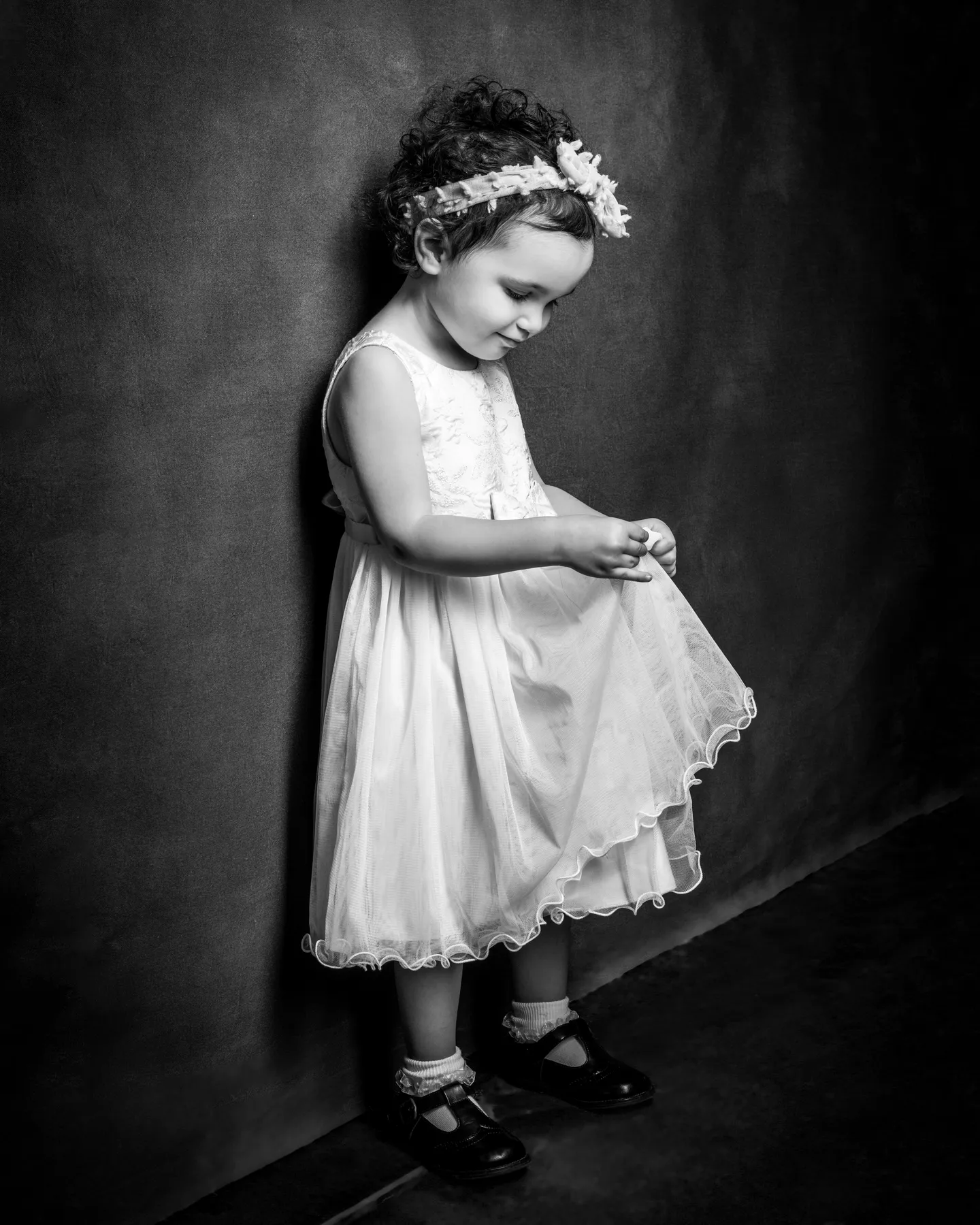Young girl holding her dress during family portrait session at Richard Hill Studio in Dallas